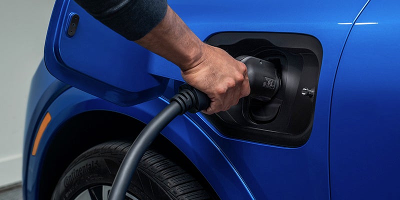 Image of a person connecting the charger to the 2026 Chevrolet Equinox-EV