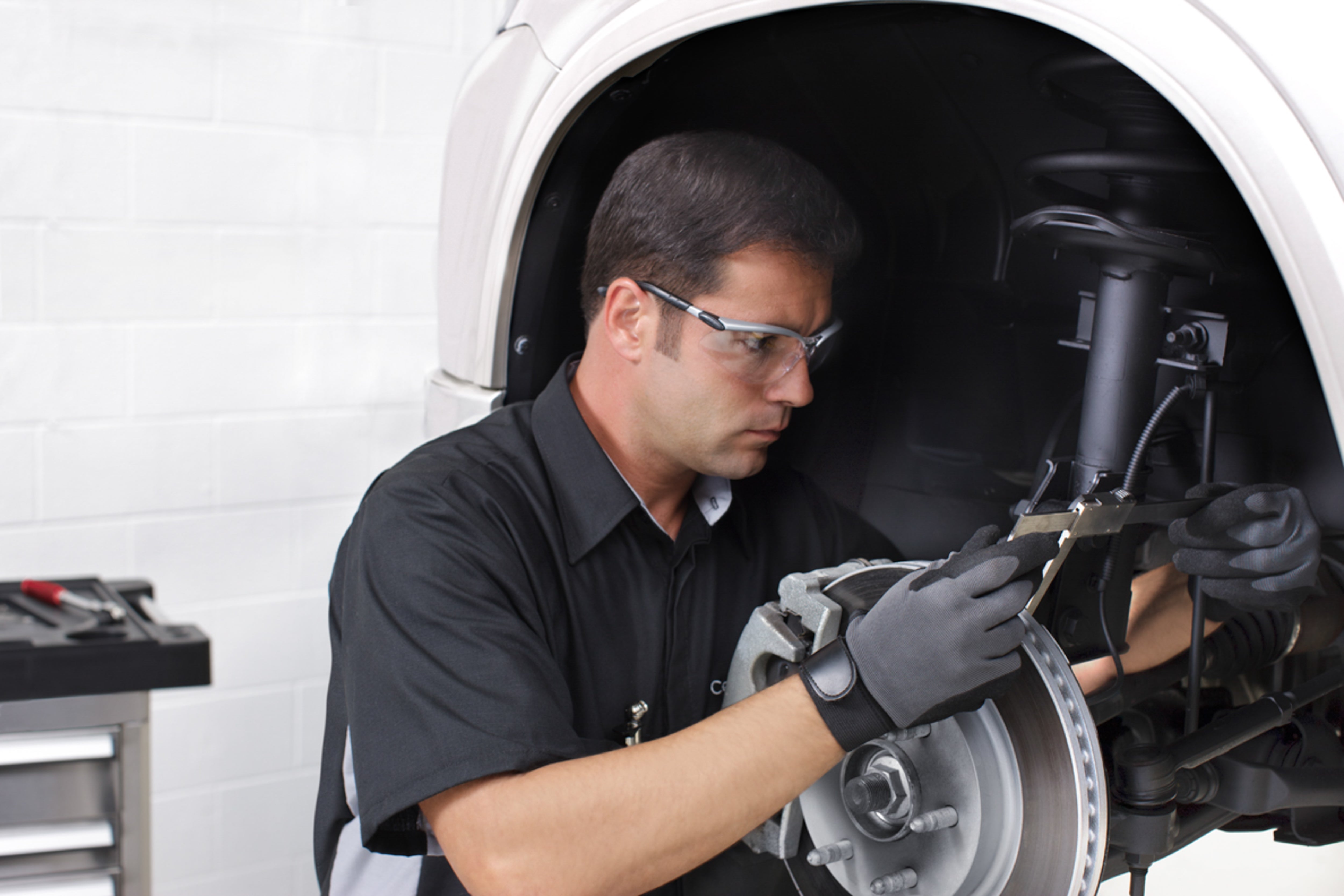 Image of service technician checking veheicle's brake pads life