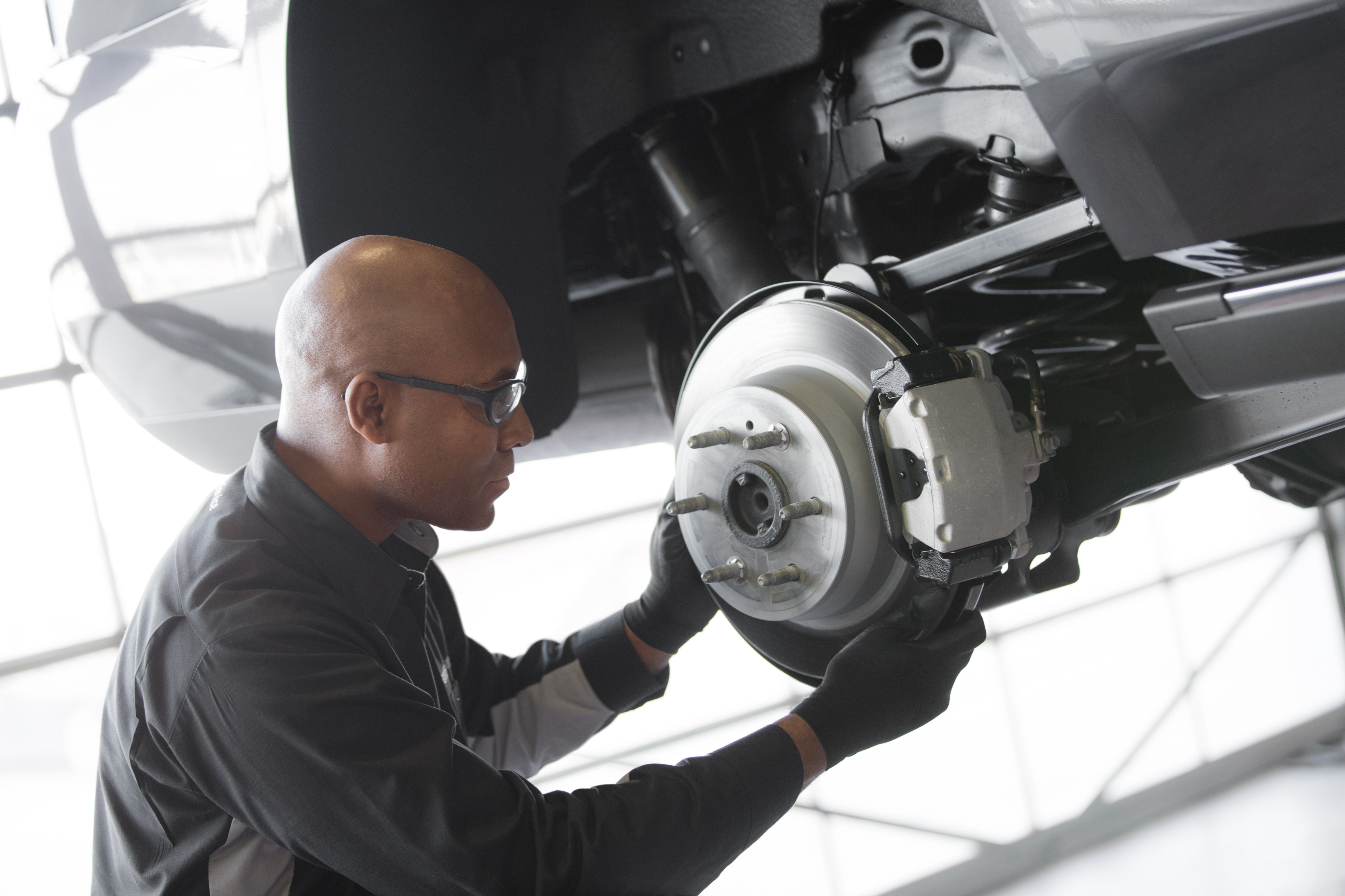 Image of service technician working on vehicle's brake