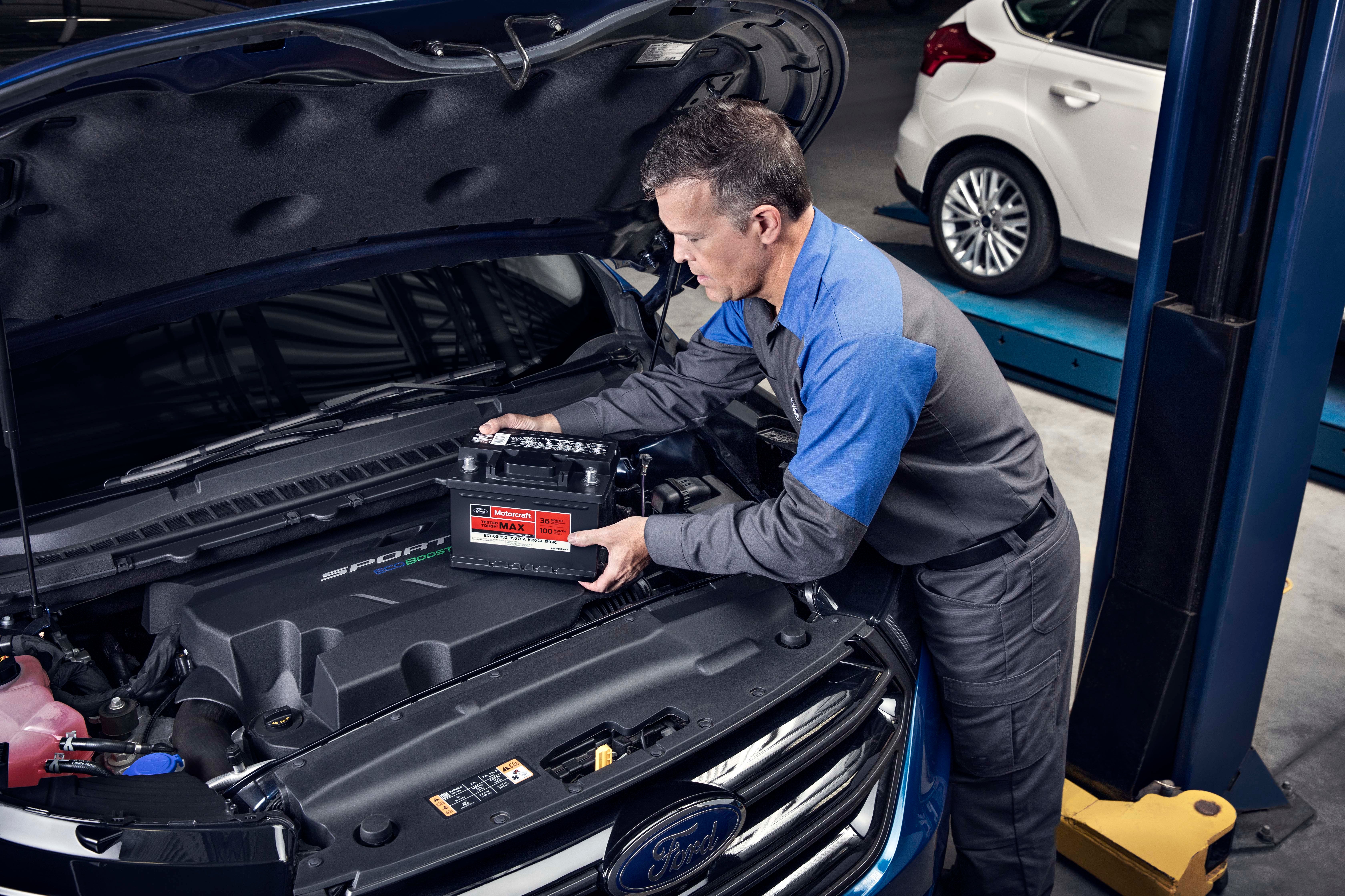 Image of service technician replacing veheicle's battery