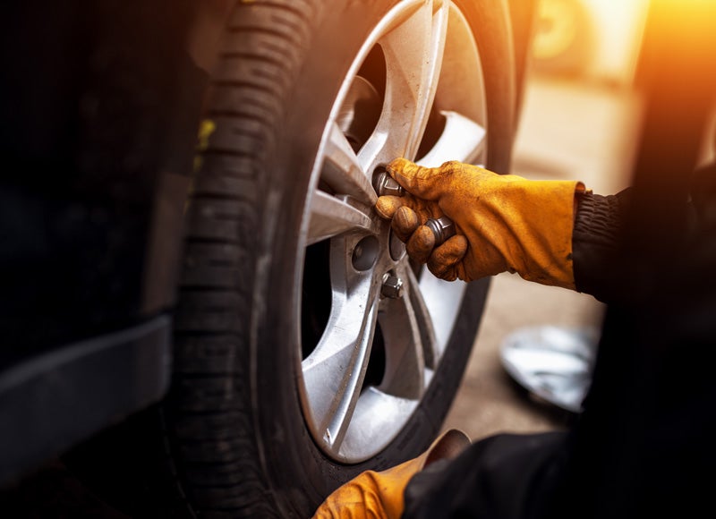 Image of service team member tighting the vehicle's tire bolts